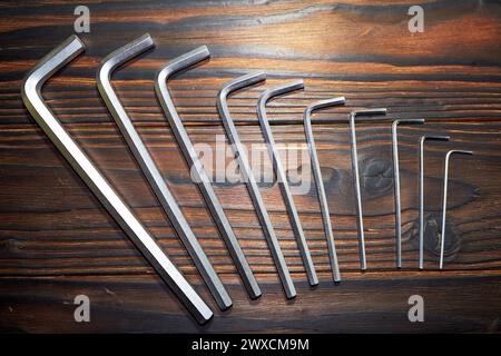 Set of hex key (Allen wrench or Allen key) of various sizes on a wooden table Stock Photo