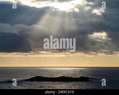 Rays of sunlight beaming down shining through the grey clouds in the sky on the ocean below, majesty, NSW Australia Stock Photo