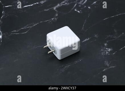 two pin smatphone white color charger isolated on black marble background Stock Photo