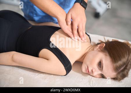 Chiropractor gives a massage to a young patient Stock Photo