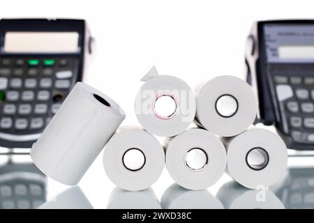 Several rolls of paper cash register tape on the background of cash registers. Stock Photo