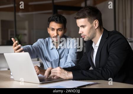 Two diverse business men talking at laptop, discussing online job Stock Photo