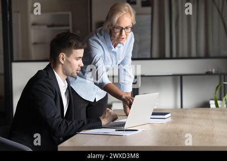 Two serious project managers working on project at laptop Stock Photo