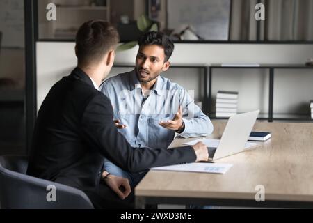 Serious focused young Indian businessman discussing job task plan Stock Photo