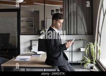 Serious company CEO man using financial app on mobile phone Stock Photo