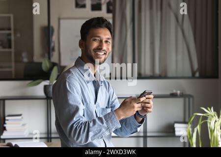 Cheerful successful Indian business professional man using financial application Stock Photo