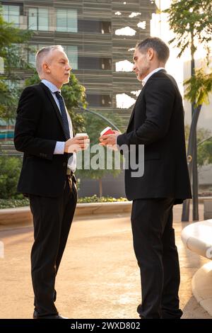 Two attractive and self-confident businessmen commenting on the results of the business project. Stock Photo