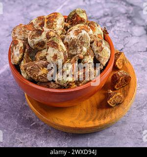 Close-up of dried dates in a wooden bowl on a marble surface Stock Photo