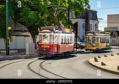 Famous and typical old red and yellow tram, beautifully decorated preserving the original designs, circulating on the tracks of a typical Lisbon stree Stock Photo