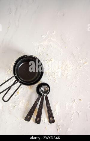 Various kitchen tools and two pans on flour surface Stock Photo