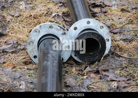 Clear bolts and screws. The pipes are located on the ground in nature. Stock Photo