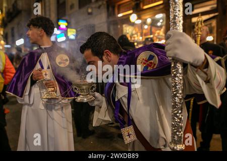 Madrid, Spain. 29th Mar, 2024. A member of the Medinaceli brotherhood blows a chalice with incense during the Good Friday procession. This Good Friday, the brotherhood of the Primary Archconfraternity of the Real and Illustrious Slavery of Nuestro Padre Jesús Nazareno de Medinaceli, popularly known as 'The Lord of Madrid, has processed like every Good Friday through the streets of the center of Madrid. Credit: SOPA Images Limited/Alamy Live News Stock Photo