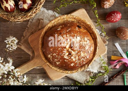 Round Czech sweet Easter cake called mazanec, with eggs dyed with onion peels and decorated  with wax on a wooden table Stock Photo