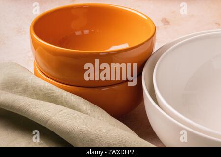 Orange and white bowls on a beige stone tabletop. Stock Photo