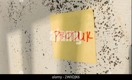 Text with the words "produk" on a note pasted on the wall Stock Photo