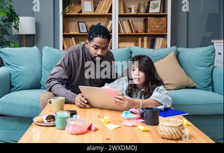 Young business people, couple, new business owners, working online from home, looking at laptop screen, having problems with company financial statist Stock Photo