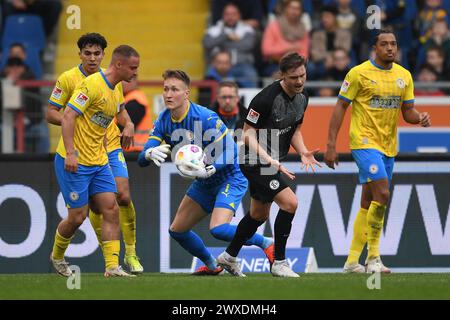 Brunswick, Germany. 30th Mar, 2024. Soccer: Bundesliga 2, Eintracht Braunschweig - SV Elversberg, Matchday 27, Eintracht Stadium. Braunschweig goalkeeper Ron-Thorben Hoffmann catches the ball. Credit: Swen Pförtner/dpa - IMPORTANT NOTE: In accordance with the regulations of the DFL German Football League and the DFB German Football Association, it is prohibited to utilize or have utilized photographs taken in the stadium and/or of the match in the form of sequential images and/or video-like photo series./dpa/Alamy Live News Stock Photo