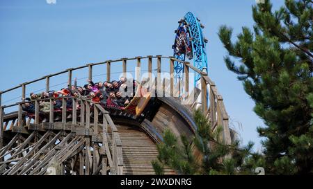 Rust, Germany-March 26.2024: Young people have fun on the wooden roller coaster 'Wodan Timburcoaster' at 'Europa-Park' with the steel roller coaster ' Stock Photo