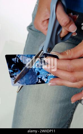 Girl cuts credit cards with scissors Stock Photo
