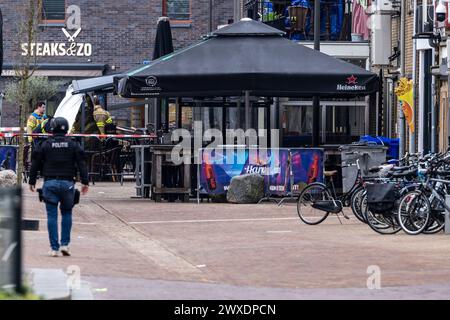 Ede, Netherlands. 30th Mar, 2024. Police officers and firefighters stand near the scene of the crime. The hostage-taking in a café lasted several hours until one man left the scene and was taken into police custody. Credit: Christoph Reichwein/dpa/Alamy Live News Stock Photo