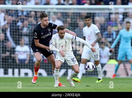 Luton Town's Reece Burke (left) and Tottenham Hotspur's James Maddison battle for the ball during the Premier League match at the Tottenham Hotspur Stadium, London. Picture date: Saturday March 30, 2024. Stock Photo