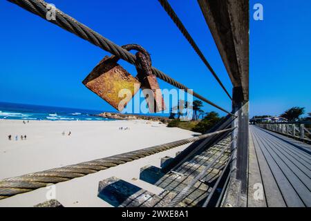 A closeup shot of love locks on metal cables in a beach setting Stock Photo