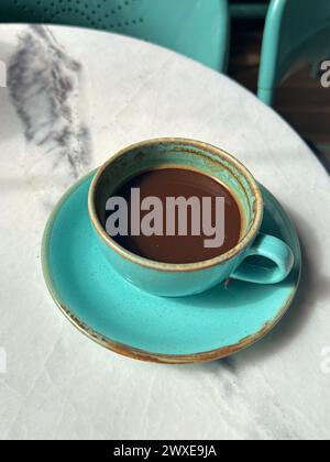 Fresh coffee in a turquoise colored cup and saucer at a coffee shop in Izmir, Turkey Stock Photo
