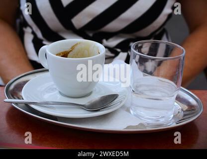 mpty coffee cup and glass on a metal tray - coffee is finished Stock Photo