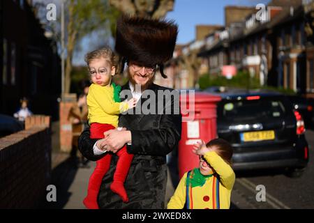 LONDON, UK, 24th March. The Jewish community in Stamford Hill, London celebrate the religious festival of Purim. Young men to dance in the streets and children dress in masks and costumes. Stock Photo