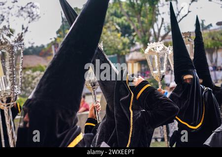 Antigua, Guatemala. 29th Mar, 2024. A confraternity of penitents, wearing capirote hats, wait outside the Escuela de Cristo church for the start of the Senor Sepultado Good Friday procession during Semana Santa, March 29, 2024 in Antigua, Guatemala. The opulent procession is one of the largest in the world involving thousands of devotees and lasting 12-hours. Credit: Richard Ellis/Richard Ellis/Alamy Live News Stock Photo