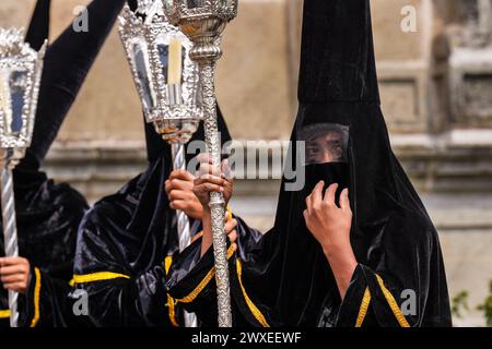 Antigua, Guatemala. 29th Mar, 2024. A confraternity of penitents, wearing capirote hats, wait outside the Escuela de Cristo church for the start of the Senor Sepultado Good Friday procession during Semana Santa, March 29, 2024 in Antigua, Guatemala. The opulent procession is one of the largest in the world involving thousands of devotees and lasting 12-hours. Credit: Richard Ellis/Richard Ellis/Alamy Live News Stock Photo