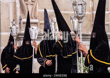 Antigua, Guatemala. 29th Mar, 2024. A confraternity of penitents, wearing capirote hats, wait outside the Escuela de Cristo church for the start of the Senor Sepultado Good Friday procession during Semana Santa, March 29, 2024 in Antigua, Guatemala. The opulent procession is one of the largest in the world involving thousands of devotees and lasting 12-hours. Credit: Richard Ellis/Richard Ellis/Alamy Live News Stock Photo