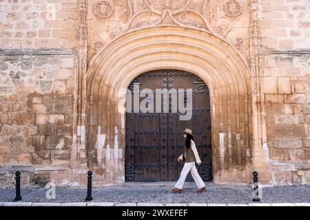 Middle aged female traveler walking on historical gate of The church of Our Lady of the Assumption wich is a 16th century catholic Church in Tembleque Stock Photo