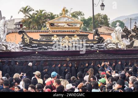 Antigua, Guatemala. 29th Mar, 2024. The glass casket containing a statue of Jesus is carried on a massive processional float at the Senor Sepultado Escuela de Cristo Good Friday procession during Semana Santa, March 29, 2024 in Antigua, Guatemala. The opulent processions, detailed alfombras and centuries-old traditions attract more than 1 million people to the ancient capital city. Credit: Richard Ellis/Richard Ellis/Alamy Live News Stock Photo