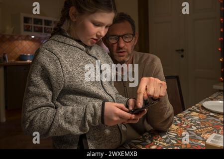 Father and daughter, 10 years old, looking for something with their mobile phone, Mecklenburg-Vorpommern, Germany Stock Photo