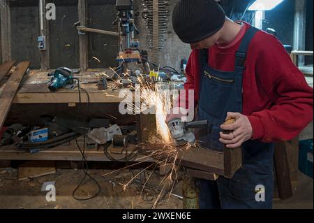 Young man at a Flex in his workshop, Mecklenburg-Vorpommern, Germany Stock Photo