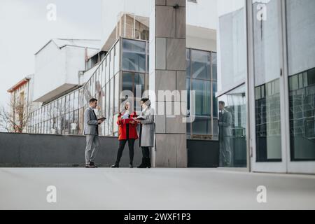 Business partners discussing strategies outside modern office building Stock Photo