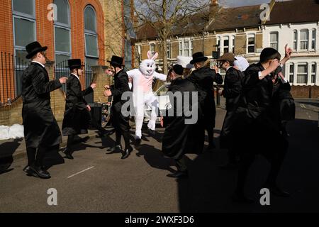 LONDON, UK, 24th March. The Jewish community in Stamford Hill, London celebrate the religious festival of Purim. Young men to dance in the streets and children dress in masks and costumes. Stock Photo