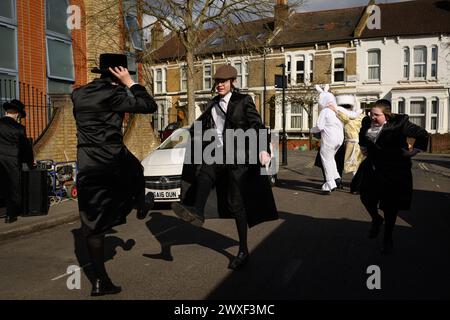 LONDON, UK, 24th March. The Jewish community in Stamford Hill, London celebrate the religious festival of Purim. Young men to dance in the streets and children dress in masks and costumes. Stock Photo