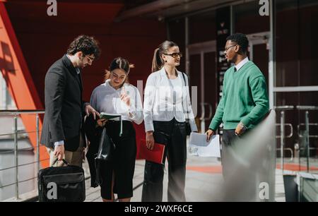 Business professionals discussing work in an urban outdoor setting on a sunny day Stock Photo