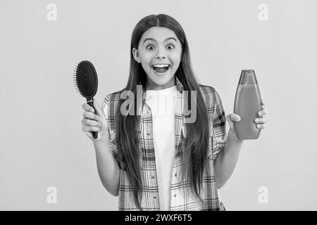 haircare of amazed teen girl with hairbrush. teen girl taking care of her hair with a hairbrush, haircare. teen girl haircare by combing hair isolated Stock Photo