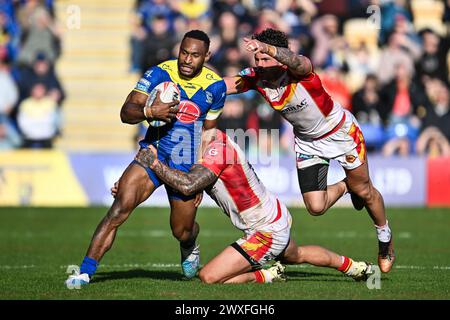 Rodrick Tai of Warrington Wolves is tackled by Tariq Sims of Catalan Dragons during the Betfred Super League match Warrington Wolves vs Catalans Dragons at Halliwell Jones Stadium, Warrington, United Kingdom, 30th March 2024  (Photo by Craig Thomas/News Images) Stock Photo