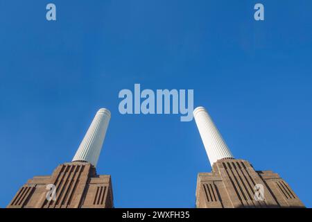 Two Isolated Battersea Power Station Chimneys London against a blue sky Stock Photo