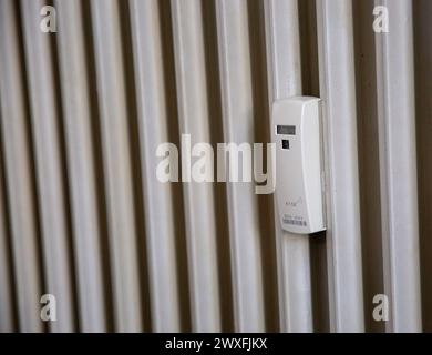 Close up of a wireless heat meter on old white radiator. Heating of houses in the cold season Stock Photo