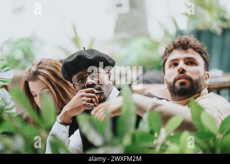 International business colleagues in a brainstorming session at a restaurant, using a laptop and engaging in a lively discussion. Stock Photo