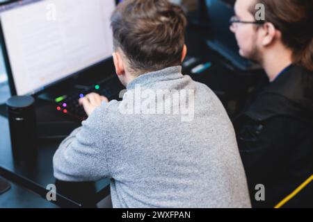 Software developer students in auditorium hall working on computer and ...