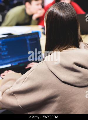 Software developer students in auditorium hall working on computer and laptop, programming contest hackathon competition, pc with coding program app, Stock Photo