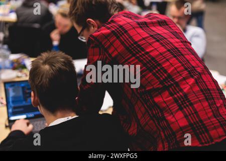 Software developer students in auditorium hall working on computer and laptop, programming contest hackathon competition, pc with coding program app, Stock Photo