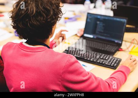 Software developer students in auditorium hall working on computer and laptop, programming contest hackathon competition, pc with coding program app, Stock Photo