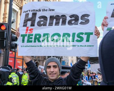 London, UK, 30th March, 2024. A protester holds up a sign at an Israeli counter-demonstration held along the route of the eleventh national Palestinian march. The group carried the national flag and kidnapped posters, as they called for the release of hostages still held in Gaza. Credit: Eleventh Hour Photography/Alamy Live News Stock Photo